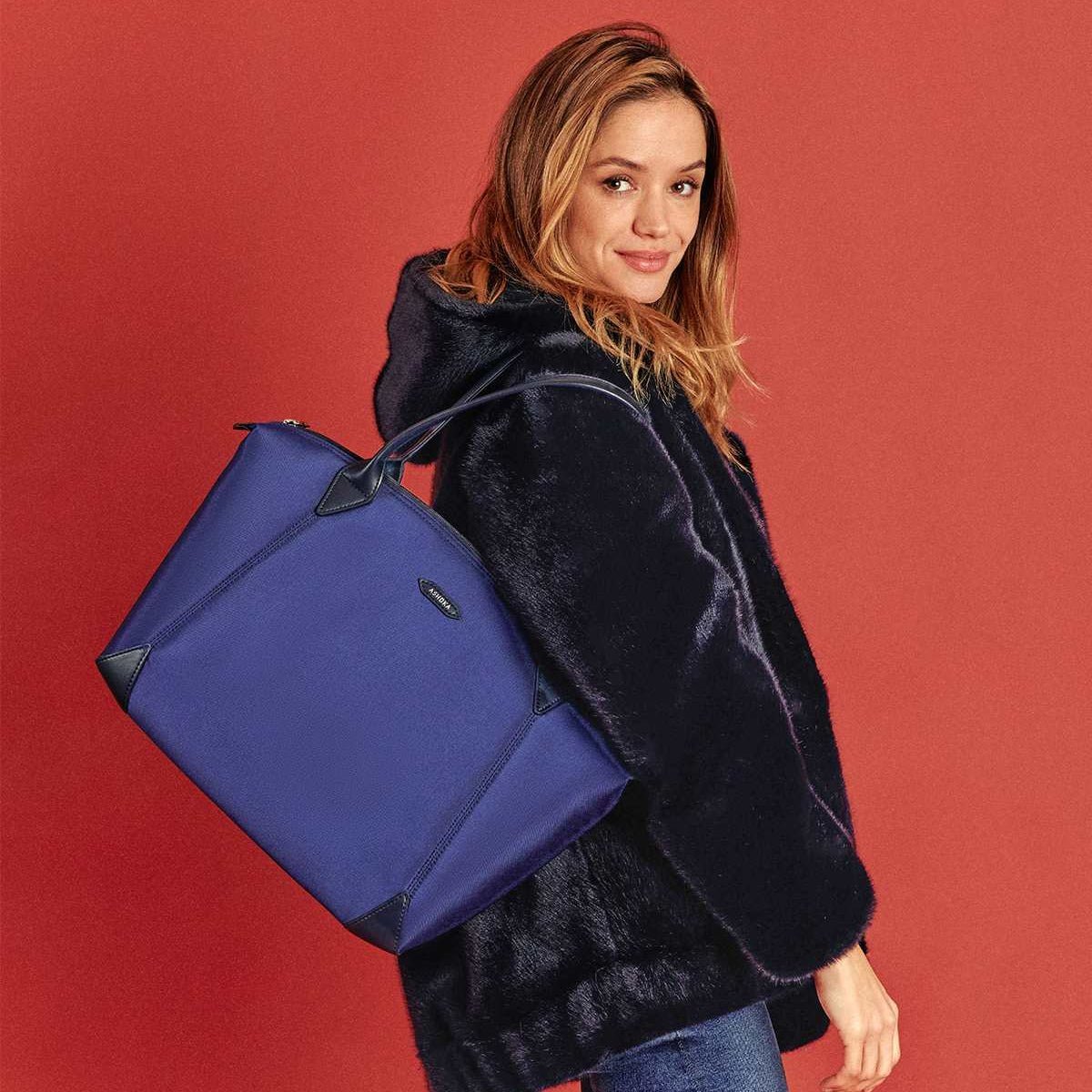 Sac vegan de voyage bleu en nylon porté par une femme pour la collection Kromatik au nom de la marque ASHOKA PARIS