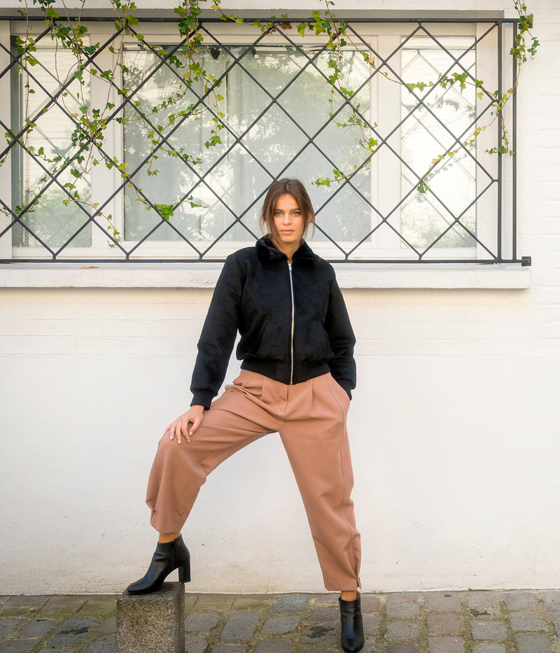 Blouson vegan pour femme, fabriqué en France. Confectionné en suédine de polyester recyclé de couleur noir, agrémenté de fausse fourrure, ce blouson est conçu à Paris. Explorez notre gamme de vêtements vegan, notamment nos manteaux écologiques et écoresponsables pour femme. Chaque pièce est fabriquée dans le respect de conditions éthiques, en utilisant des matières provenant d'Italie et respectueuses de l'environnement.