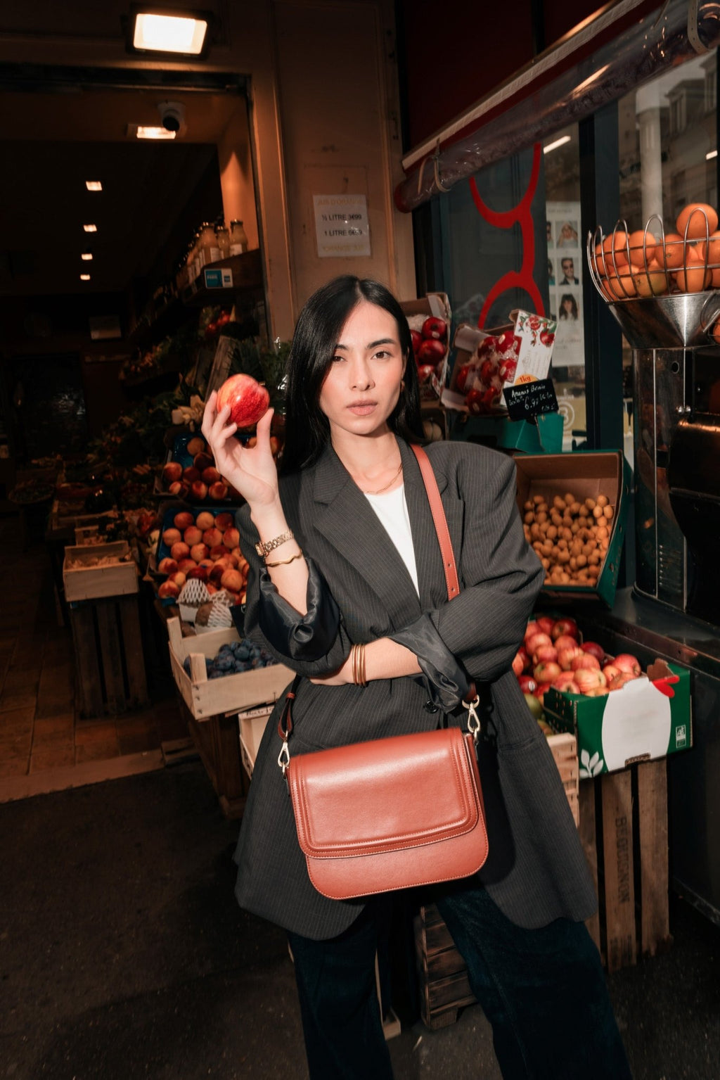 Femme avec un sac en cuir de pomme et une pomme dans la main représentant le Brigitte Couture Camel