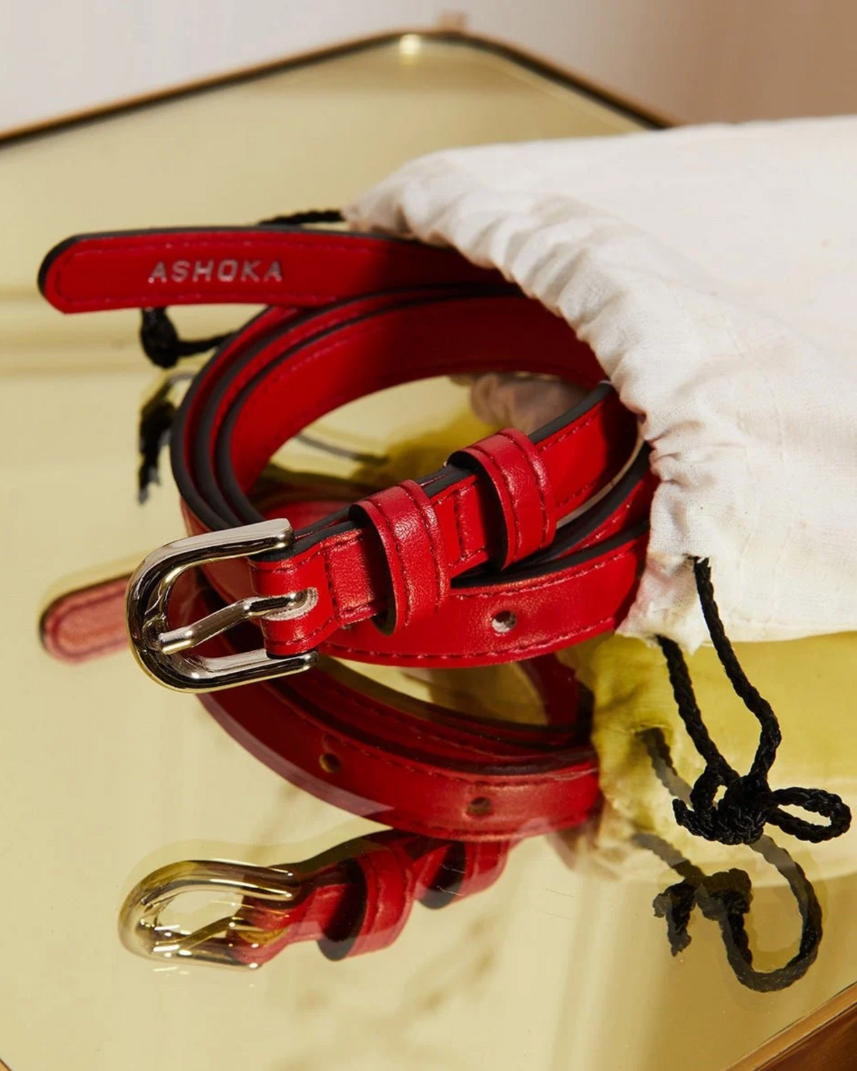 Ceinture femme vegan Uppeal™ rouge portée, boucle à ardillon en laiton finition nickel vernis
