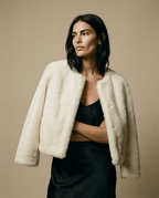 Veste courte Sophie blanche en fourrure vegan portée sur tenue sombre, contraste élégant et moderne